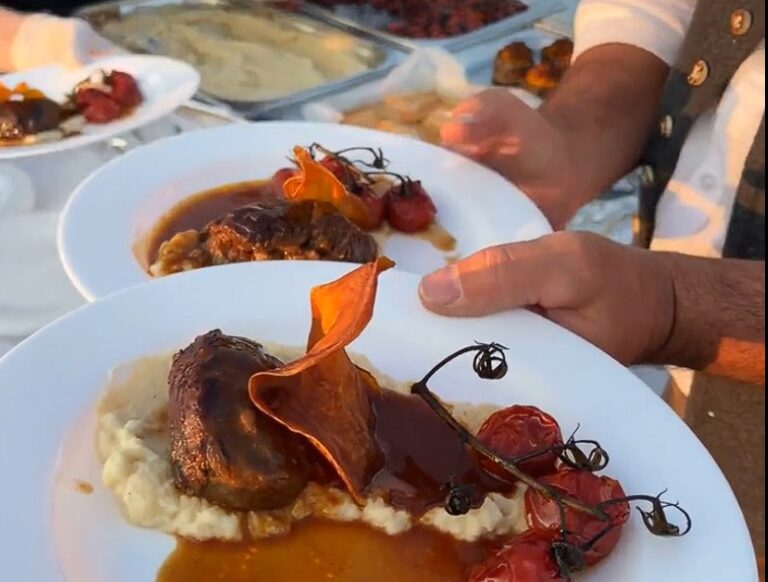 Eine Person hält einen Teller mit Essen in der Hand